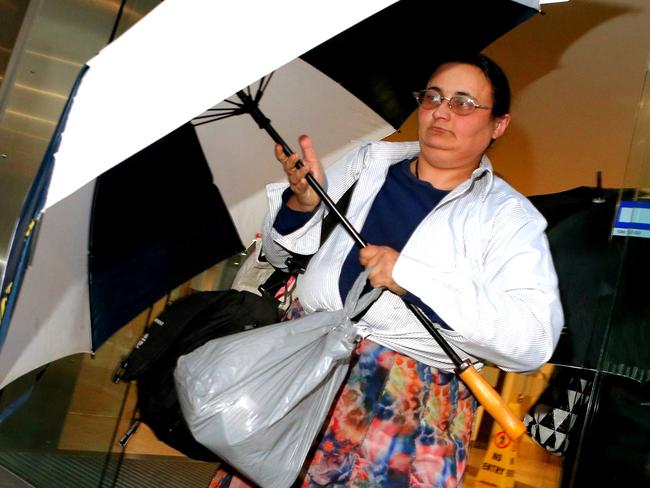 Elena Bobolas leaves court holding a plastic bag filled with cash. Picture: Stephen Cooper