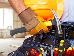 Builder handyman with construction tools. House renovation background.