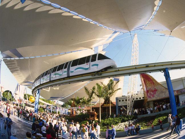 Crowds walking at the World Expo 88 as the monorail travels above.