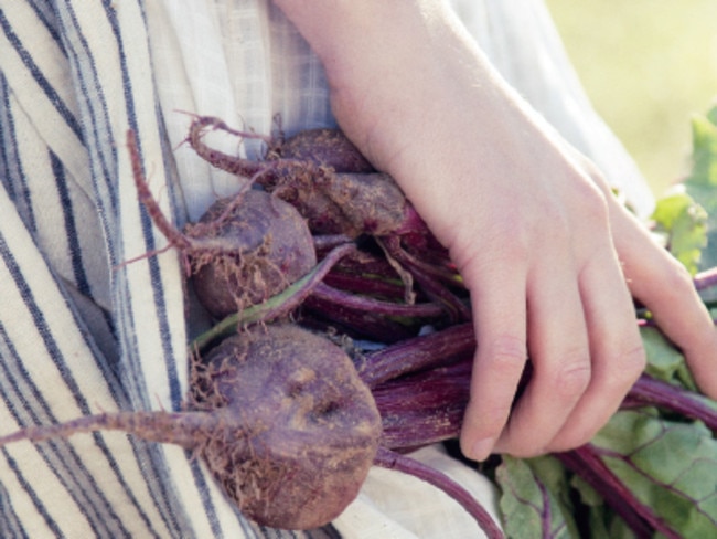 A child with some home grown beetroot from Eden Gardens.