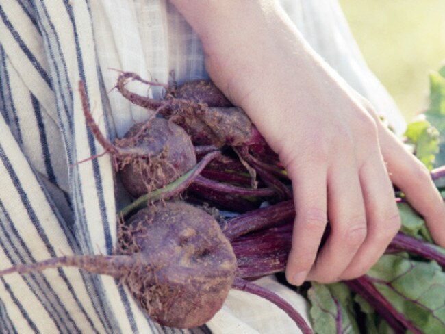 A child with some home grown beetroot from Eden Gardens.