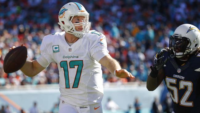 Quarterback Ryan Tannehill scrambles as he throws under pressure.