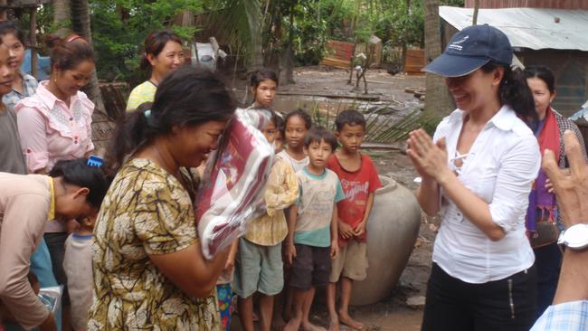 Lea Ea gifts a blanket to a villager in Cambodia on her return visit.