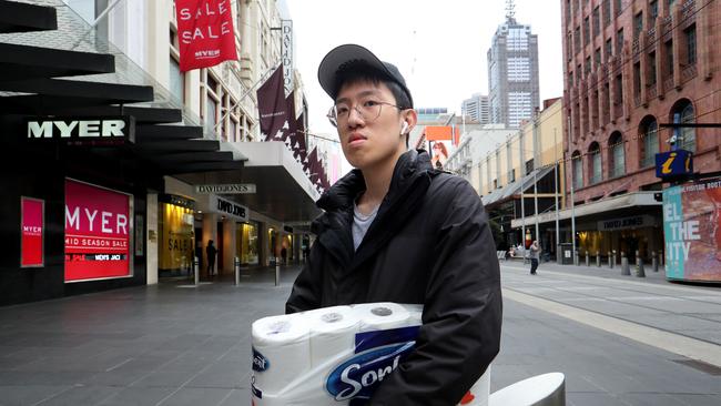 Melbourne uni student Vincent Chaidir in a deserted Bourke St mall after buying some essentials when the stores opened in Melbourne CBD. Picture: David Geraghty