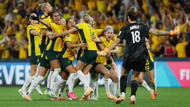 Matildas goalkeeper Mackenzie Arnold heads for her team-mates amid wild scenes in Brisbane. Picture: Lachie Millard