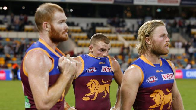 Dejected Lions players Daniel Merrett, Mitch Robinson and Daniel Rich after the loss to Collingwood