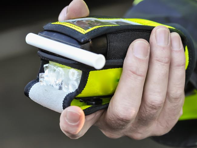 Belfast, Northern Ireland. 24 Nov 2016 - A police officer holds a roadside breathalyser alcohol breath test after taking a sample from a driver.