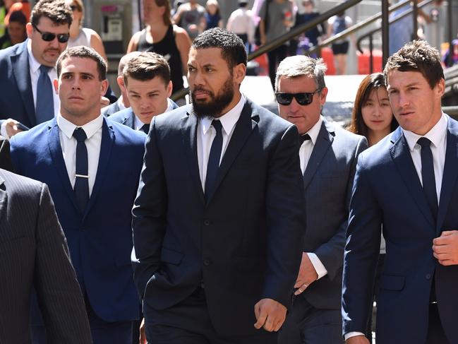 Canterbury Bankstown Bulldogs NRL players Adam Elliott (second left), Asipeli Fine (centre) and team captain Josh Jackson (right) leave the Downing Centre Court following an adjournment in Sydney, Monday, December, 17, 2018. Elliott are Fine are charged with wilful and obscene exposure during Mad Monday celebrations. (AAP Image/Dean Lewins) NO ARCHIVING