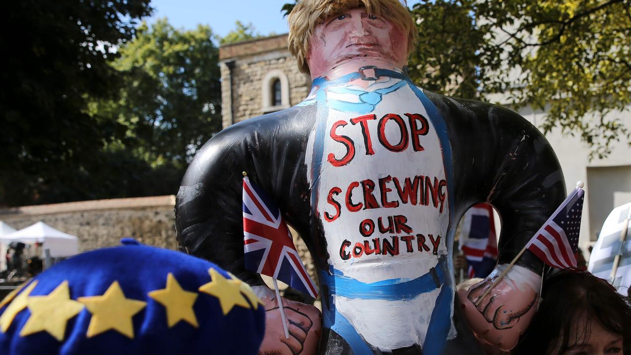 Anti-Brexit activists pose with an inflatable effigy of Britain's Prime Minister Boris Johnson outside the Houses of Parliament in London. Picture: ISABEL INFANTES / AFP.