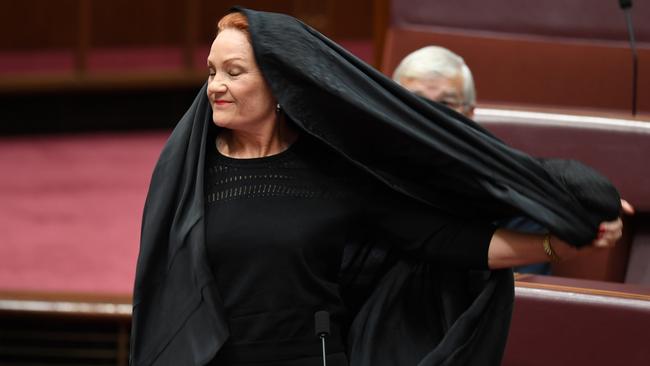 One Nation Senator Pauline Hanson takes off a burqa after the Senate Question Time stunt last year. Picture: AAP/Lukas Coch