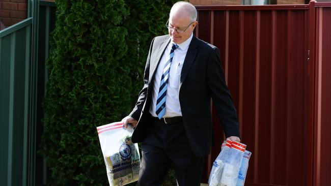 Investigators removing items from a raid on a house in Wenke Ave Bankstown this morning. Picture: Gaye Gerard