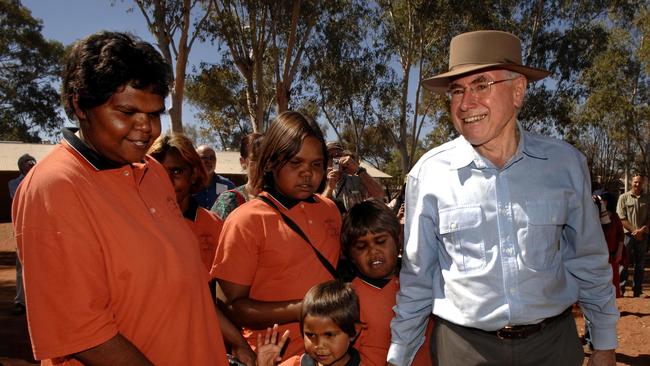 Prime Minister John Howard speaks with children at Hermannsburg. Picture: File