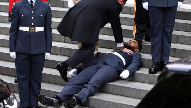 A member of the military faints on the steps ahead of the National Service of Thanksgiving for The Queen's reign at Saint Paul's Cathedral. Picture: Henry Nicholls/AFP