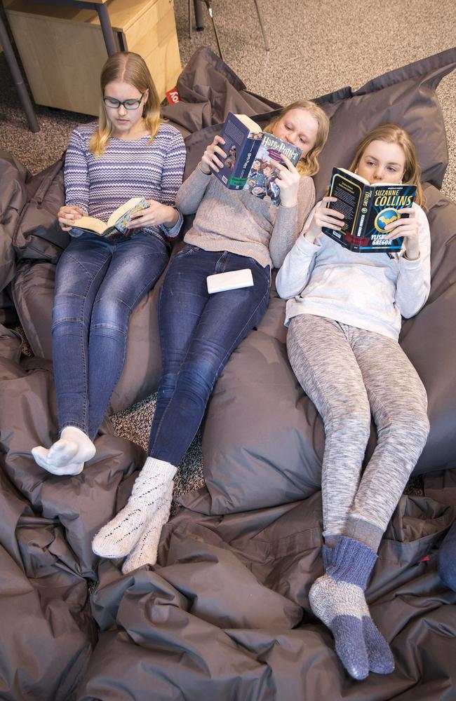 Hiidenkiven Pereskoulu School students Vilma, 14, Lotta, 15, and Sonja, 15, chillax in the library. Picture: Ella Pellegrini.