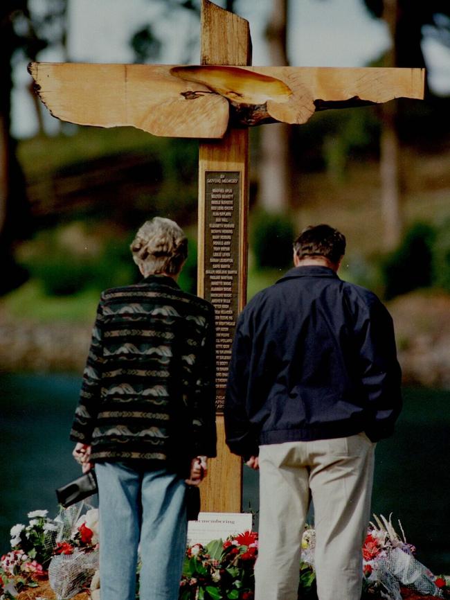 Tourists inspect a cross at Port Arthur which stands as memorial to the 35 people who died in 1996 shooting.