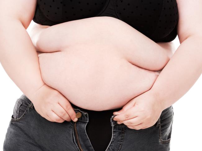 RendezView. Overweight woman trying desperately to fit into a pair of jeans that are too small. (Pic: iStock)