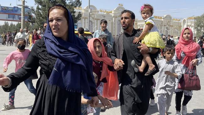 An Afghan family rushes to the Hamid Karzai International Airport as they flee Kabul. Picture: Getty