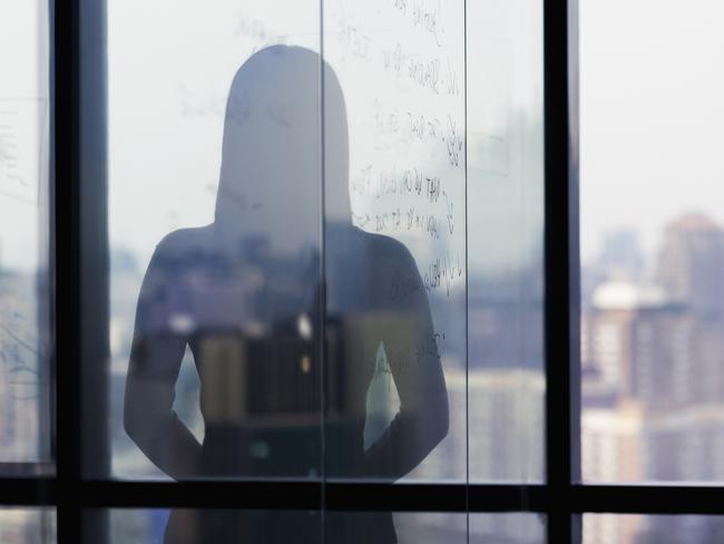 Silhouette shadow of woman looking at city from office