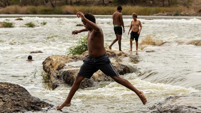 A boy jumps along rocks at Brewarrina Weir. Picture: Jenny Evans/Getty Images