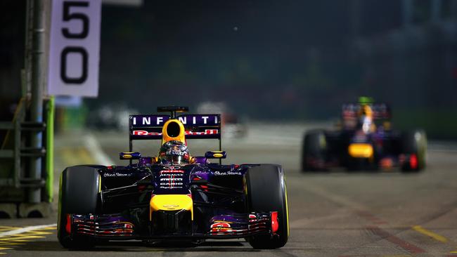 Sebastian Vettel leads his Red Bull teammate Daniel Ricciardo on the Marina Bay Street Circuit in Singapore.