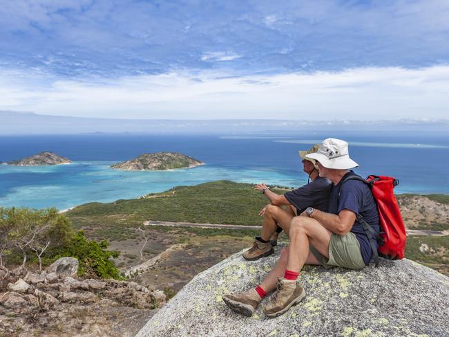 senior couple looking from spectacular view of Captain Cooks lookout from the top of Lizard Island over the Great Barrier Reef, Queensland, Australia