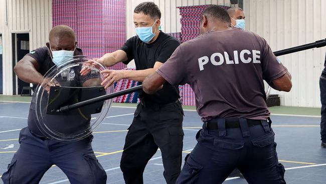 A China Police Liason Team officer (centre) trains Solomon Island police officers in unarmed combat skills. Picture: AFP / Royal Solomon Islands Police Force