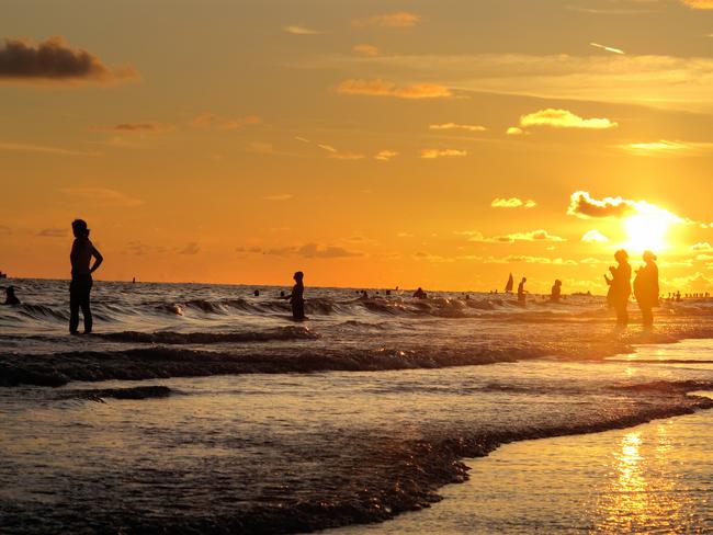 Generic hot weather, Summer, heat wave images - Beach vacations. Silhouette of people in sea at sunset.