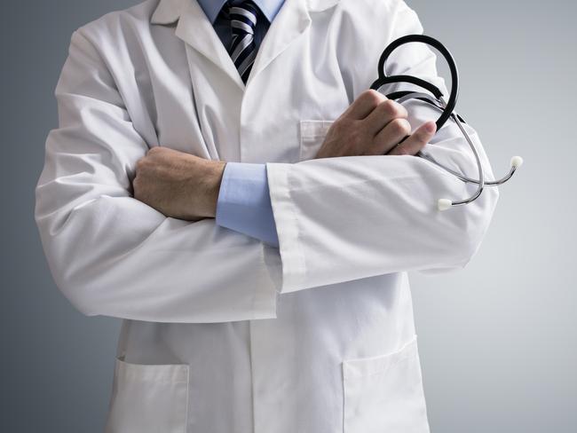 Doctor holding a stethoscope with arms crossed and copy space