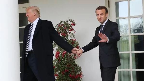 Donald Trump drags Emmanuel Macron off.