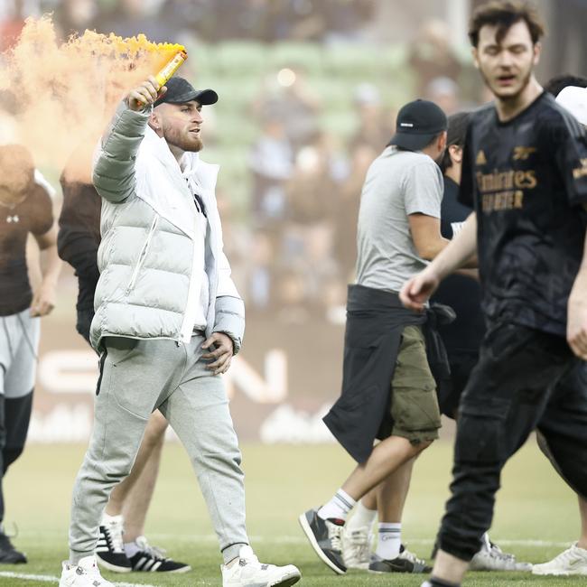 Fans storm the pitch in protest during the Melbourne derby.