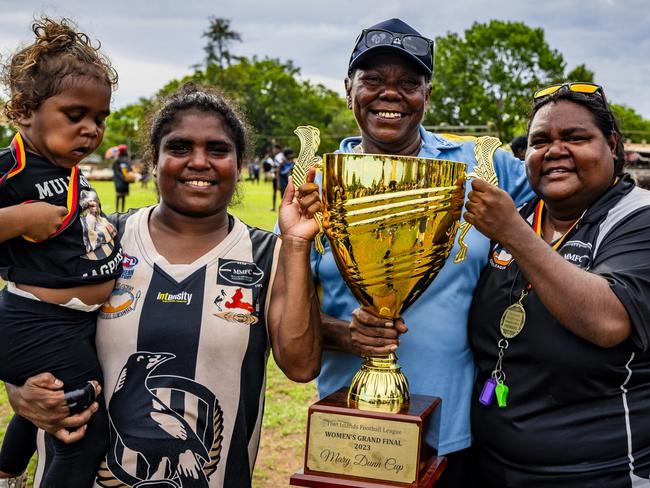 2024 Indigenous Round Honouree Mary Dunn presenting the Mary Dunn Cup to the 2023 Tiwi Islands Football League women's premiers Muluwurri Magpies (December 2023). Picture: Patch Clapp / AFLNT Media