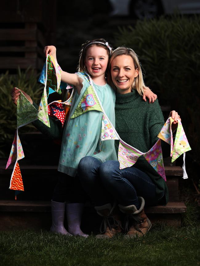 Clare Corrigan from Sustainable Living Kingborough and 5-year-old daughter Priya hold fabric bunting. Picture: ZAK SIMMONDS