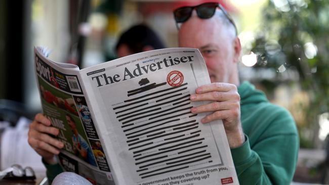 Nic Klar reads the The Advertiser’s Monday edition, with blanked-out front page to launch the Your Right To Know campaign. Picture: AAP / Kelly Barnes