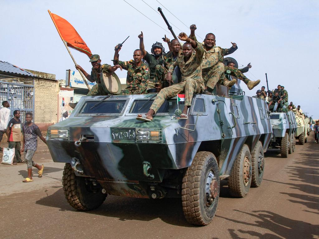 People cheer members of Sudan's armed forces taking part in a military parade held on Army Day in Gadaref. Picture: AFP