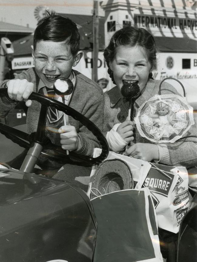 1962 — Edwin Jacobs, 9, and his sister Meredith, 7, sit on a tractor eating toffee apples.