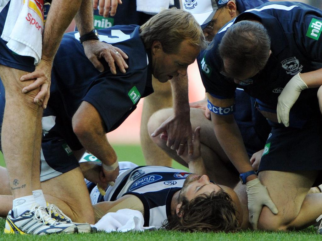 Max Rooke is attended to after a heavy knock during his career at Geelong.