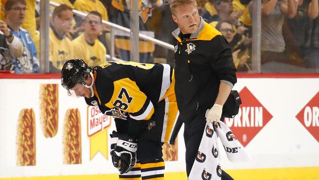 Sidney Crosby #87 of the Pittsburgh Penguins leaves the ice with trainer Chris Stewart after taking a hit in the first period.