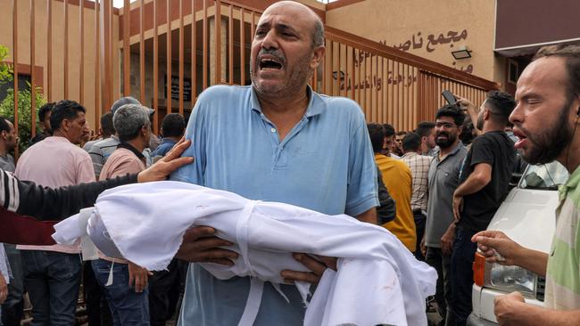 The body of a child killed in an Israeli airstrike is carried from a morgue for burial in Khan Yunis on Wednesday. Picture: AFP