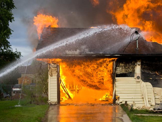 Fire hose putting out flames. House fire. Generic image.