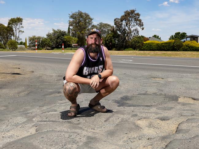 Ryan Cumberland is pictured with potholes on the corner of Northern Highway and Duke Street in Wallan. Picture: Ian Currie