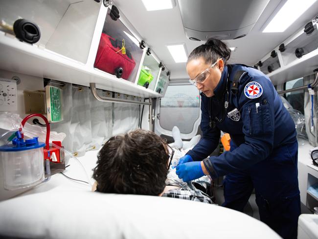 Ms Marshall treats a patients in the back on the ambulance as they make their way to Bankstown Hospital. Picture: Luke Drew