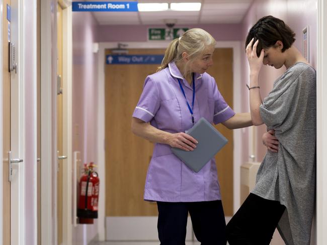 istock generic:  woman, abuse, DV, domestic violence, harassment, sexual harassment.   Medical woman comforts young female adult as she stands with her back against to the wall in a hospital corridor. Head in her hand she looks very upset. . Picture: istock