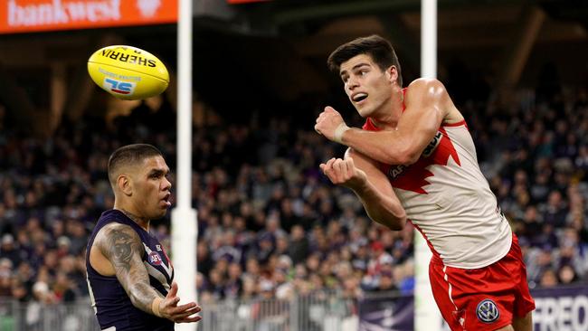 Lewis Melican handballs under pressure from Michael Walters.