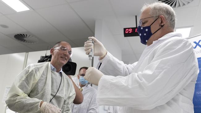 A worker is pictured at the Scientia Clinical Research Ltd lab in Sydney with Prime Minister Scott Morrison. Picture: Pool/Getty Images Via NCA NewsWire