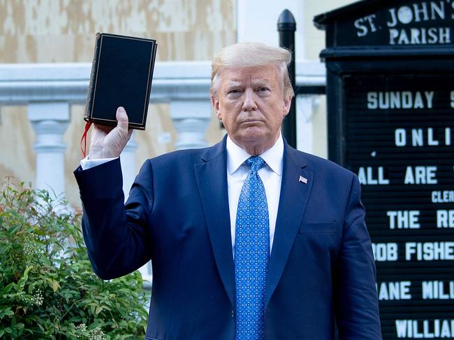 TOPSHOT - US President Donald Trump holds a Bible while visiting St. John's Church across from the White House after the area was cleared of people protesting the death of George Floyd June 1, 2020, in Washington, DC. - US President Donald Trump was due to make a televised address to the nation on Monday after days of anti-racism protests against police brutality that have erupted into violence. The White House announced that the president would make remarks imminently after he has been criticized for not publicly addressing in the crisis in recent days. (Photo by Brendan Smialowski / AFP)