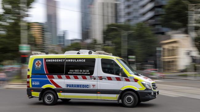 An ambulance speeds away from the Royal Melbourne Hospital. Picture: David Geraghty