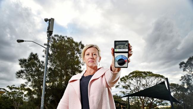 Vivian Dunstan holds an electromagnetic wave detector showing dangerous levels at Tania Park at Balgowlah on Thursday, June 13. Local residents are concerned about the possible dangers of 5G, and the towers at Tania Park, next to a playground, are proposed for an upgrade to 5g. (AAP IMAGE / Troy Snook)