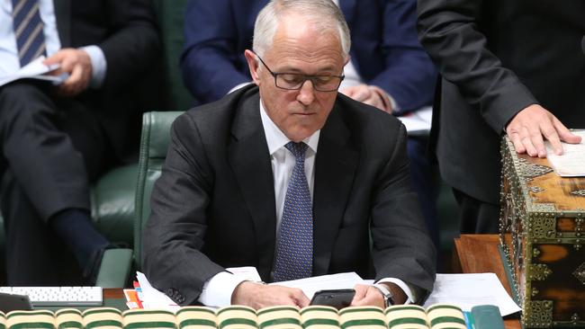 Malcolm Turnbull checks his phone during Question Time. Picture: Kym Smith