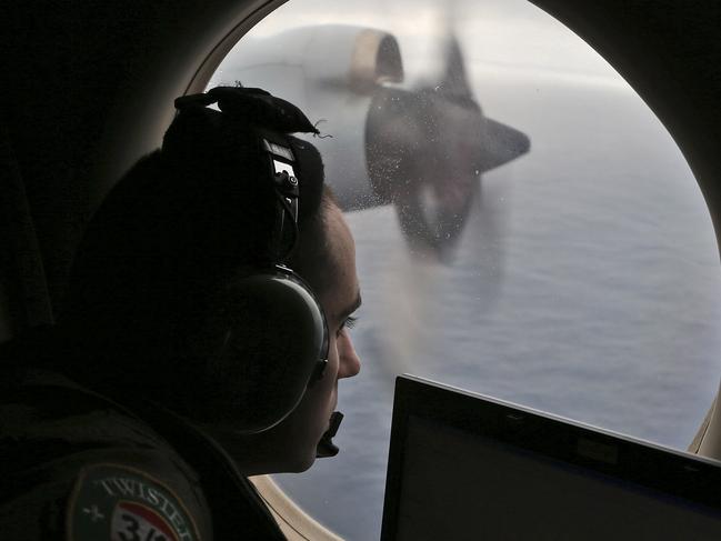 FILE - In this March 22, 2014 file photo, flight officer Rayan Gharazeddine on board a Royal Australian Air Force AP-3C Orion, searches for the missing Malaysia Airlines Flight MH370 in southern Indian Ocean, Australia. From the disappearances of aviator Amelia Earhart to labor union leader Jimmy Hoffa, there’s just something about a good mystery that Americans find too tantalizing to resist. Perhaps that's why the saga of missing Malaysia Airlines Flight 370 has continued to rivet the country long after people elsewhere have moved on. (AP Photo/Rob Griffith, File)