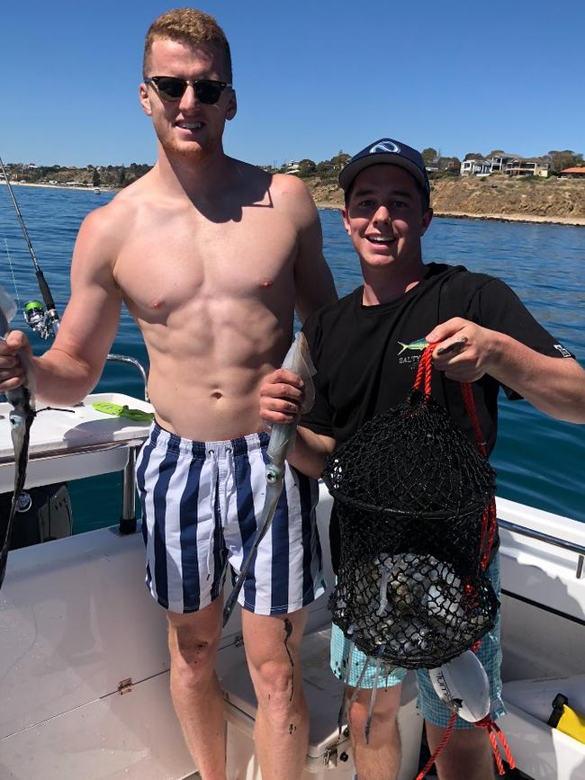 Ned McHenry (right) and Crows teammate Reilly O’Brien with a bag of squid caught off the metropolitan coastline. Picture: Supplied